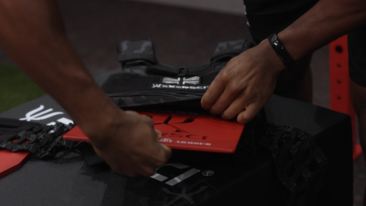 An image of a man inserting weighted vest plates into an Exersci branded weighted vest to encapsulate the Exersci blog post entitled 'Do Weighted Vests Benefit You?'