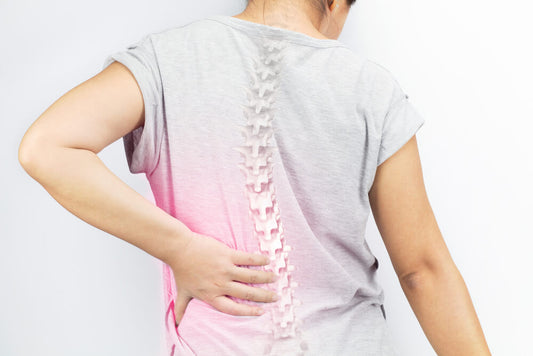 A woman grabbing her lower back in pain. This image is to illustrate the Exerscie blog entitled 'Are Weighted Vests Good For Osteoporosis?'